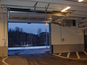 En ovanblåsande luftridå från RMK på garageport i skymningsljus.