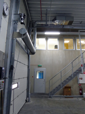 En ovanblåsande luftridå från RMK på industriport med trappa vid väggen.