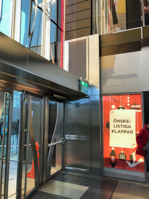 En speciallösning med luftridå från RMK på en entré med röd affisch.