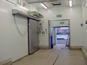 Ovanblåsande luftridå från RMK på en frys med rostfri port.