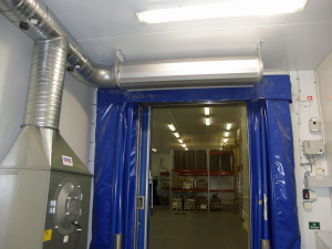 Ovanblåsande luftridå från RMK på en frys med blåa gardiner.