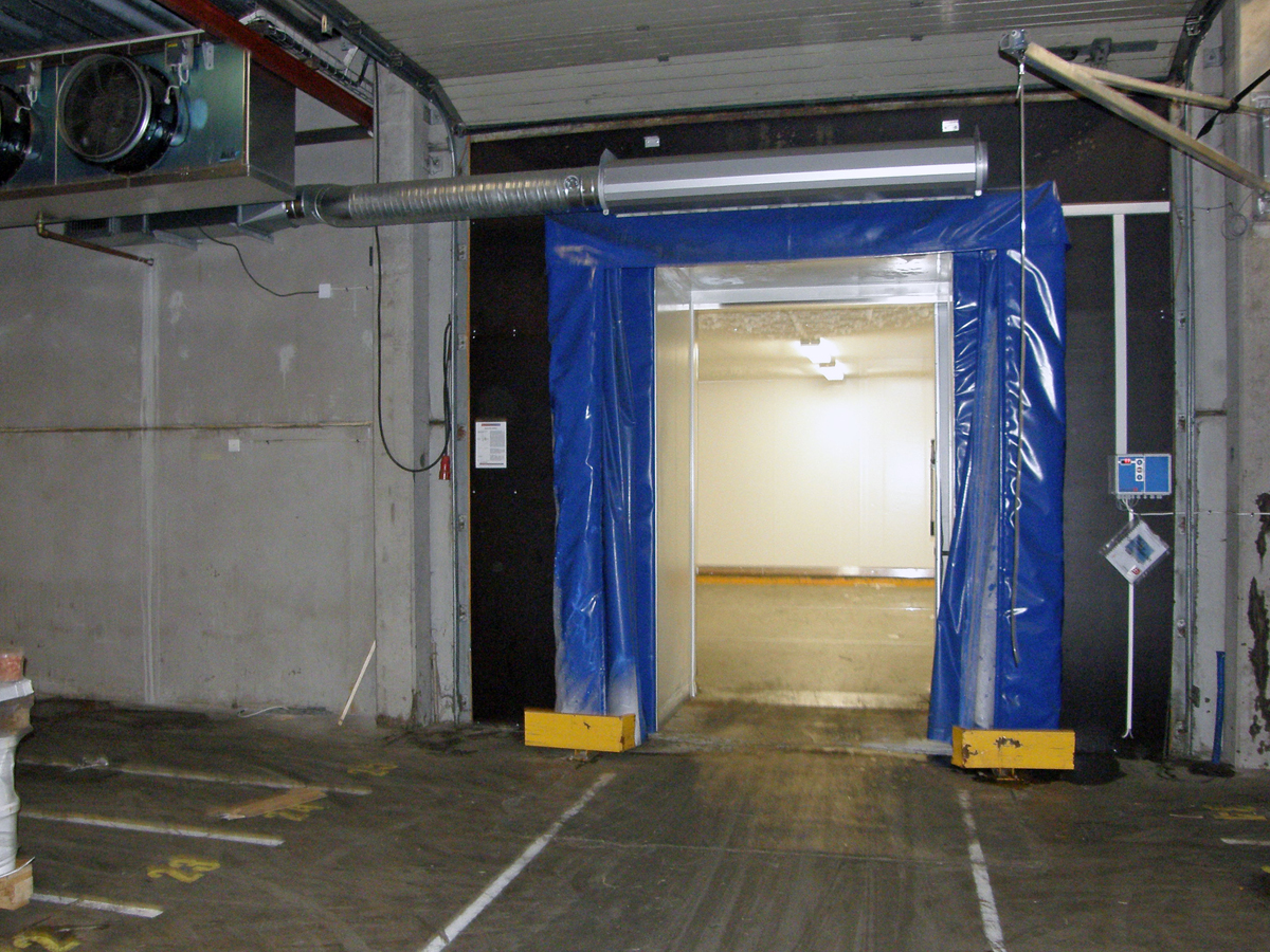 Ovanblåsande luftridå från RMK på en frys med blåa gardiner.