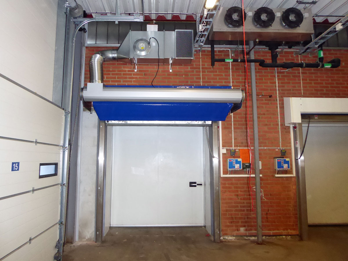 Ovanblåsande luftridå från RMK på en frys med tegelvägg bakom.