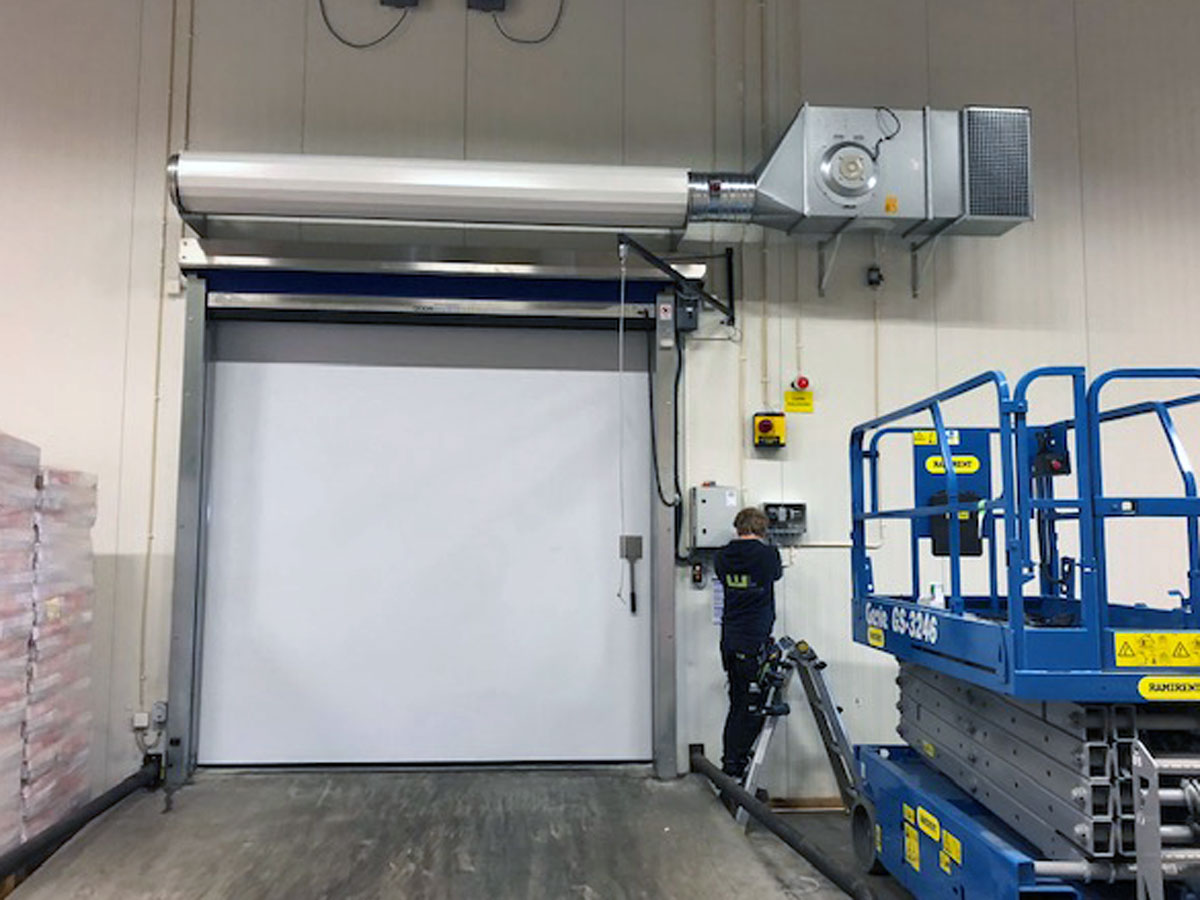 Ovanblåsande luftridå från RMK på en frys med blå saxlift.