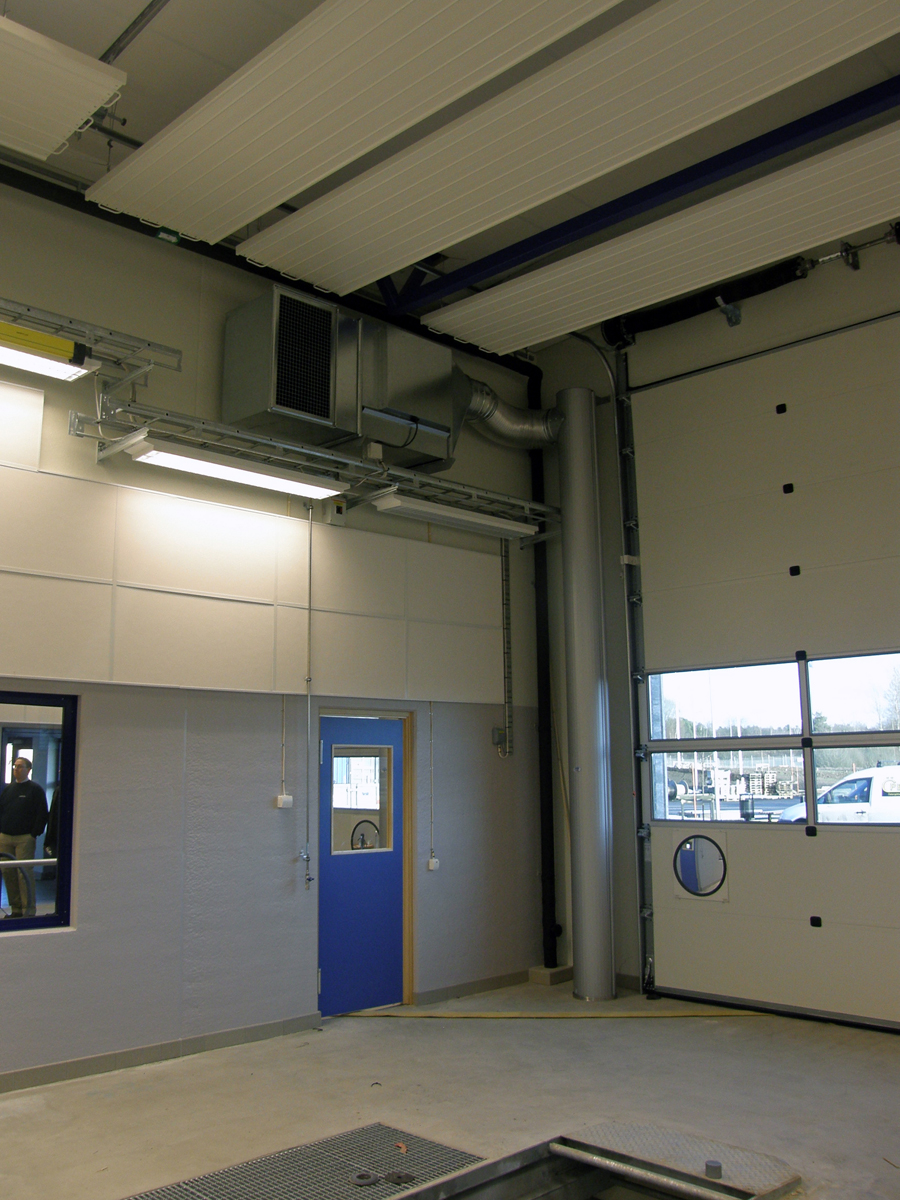 Sidoblåsande luftridåer från RMK på industriport med med blå dörr bredvid.
