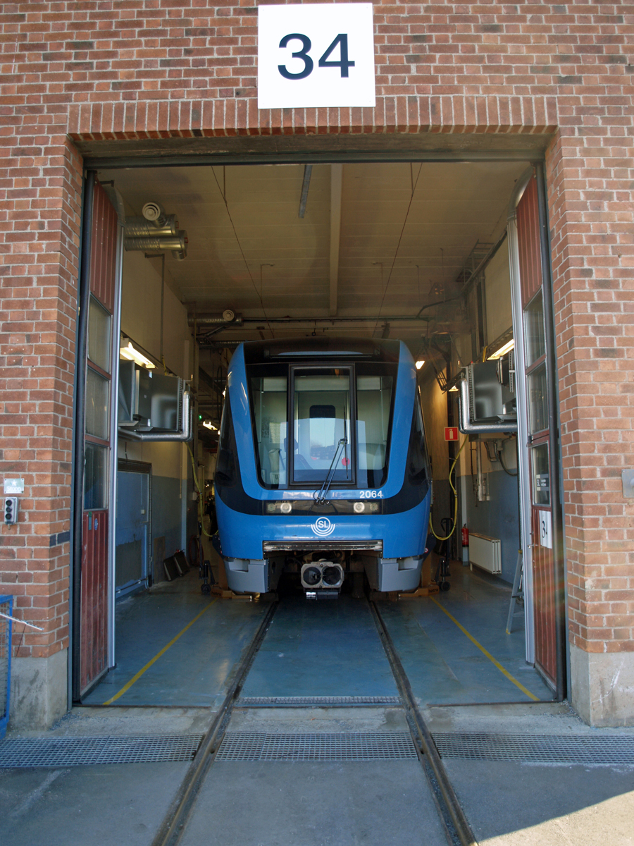 Sidoblåsande luftridåer från RMK på industriport med tunnelbanetåg.