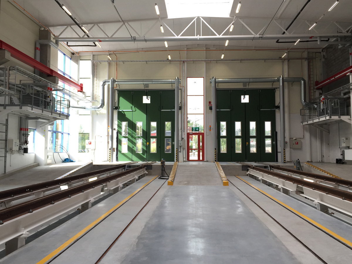 Sidoblåsande luftridåer från RMK på industriport med grön dörr.