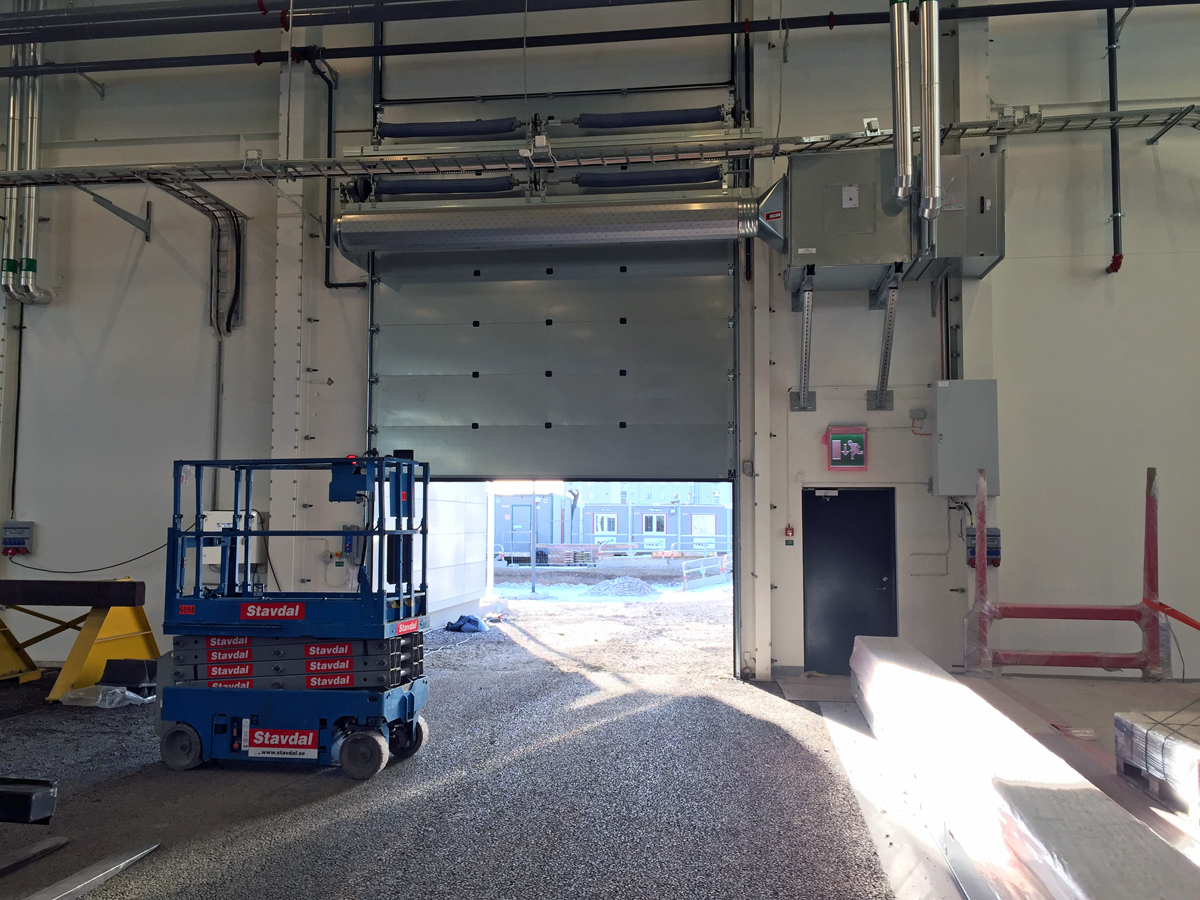 En ovanblåsande luftridå från RMK på industriport med blå saxlift.